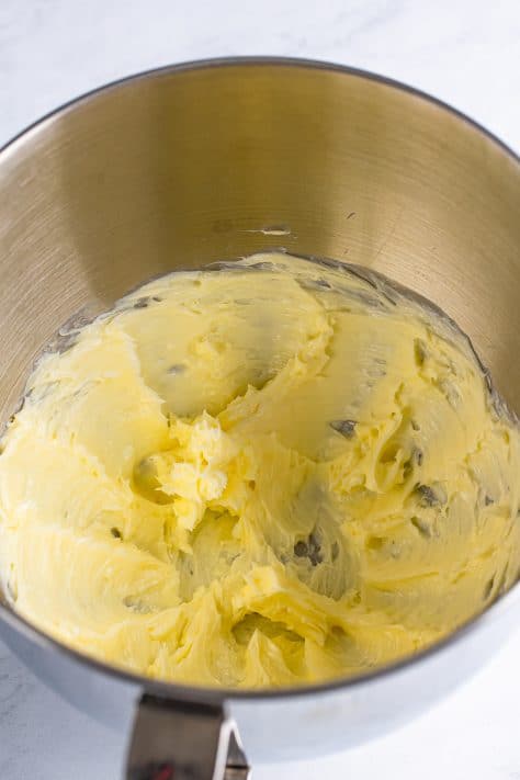 butter being whipped in the bowl of a stand mixer.