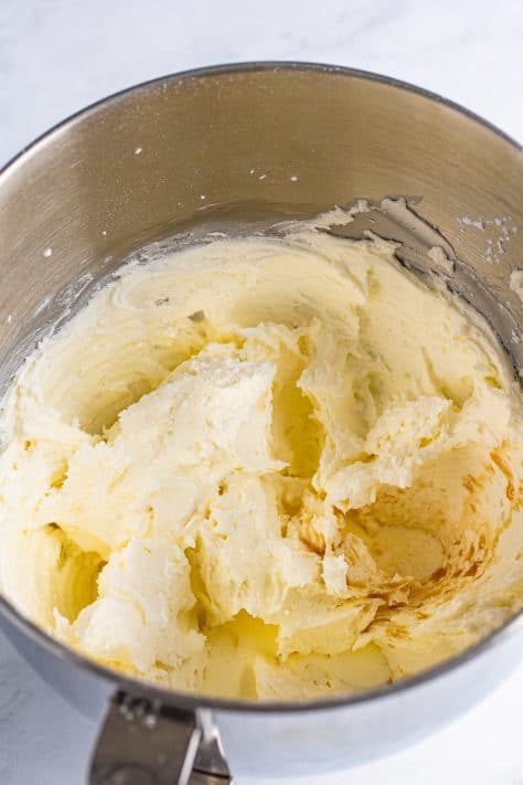 heavy cream and vanilla extract added to butter and sugar mixture in the mixing bowl.