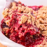Close up looking at a large serving of Raspberry Crumble in a white serving plate.