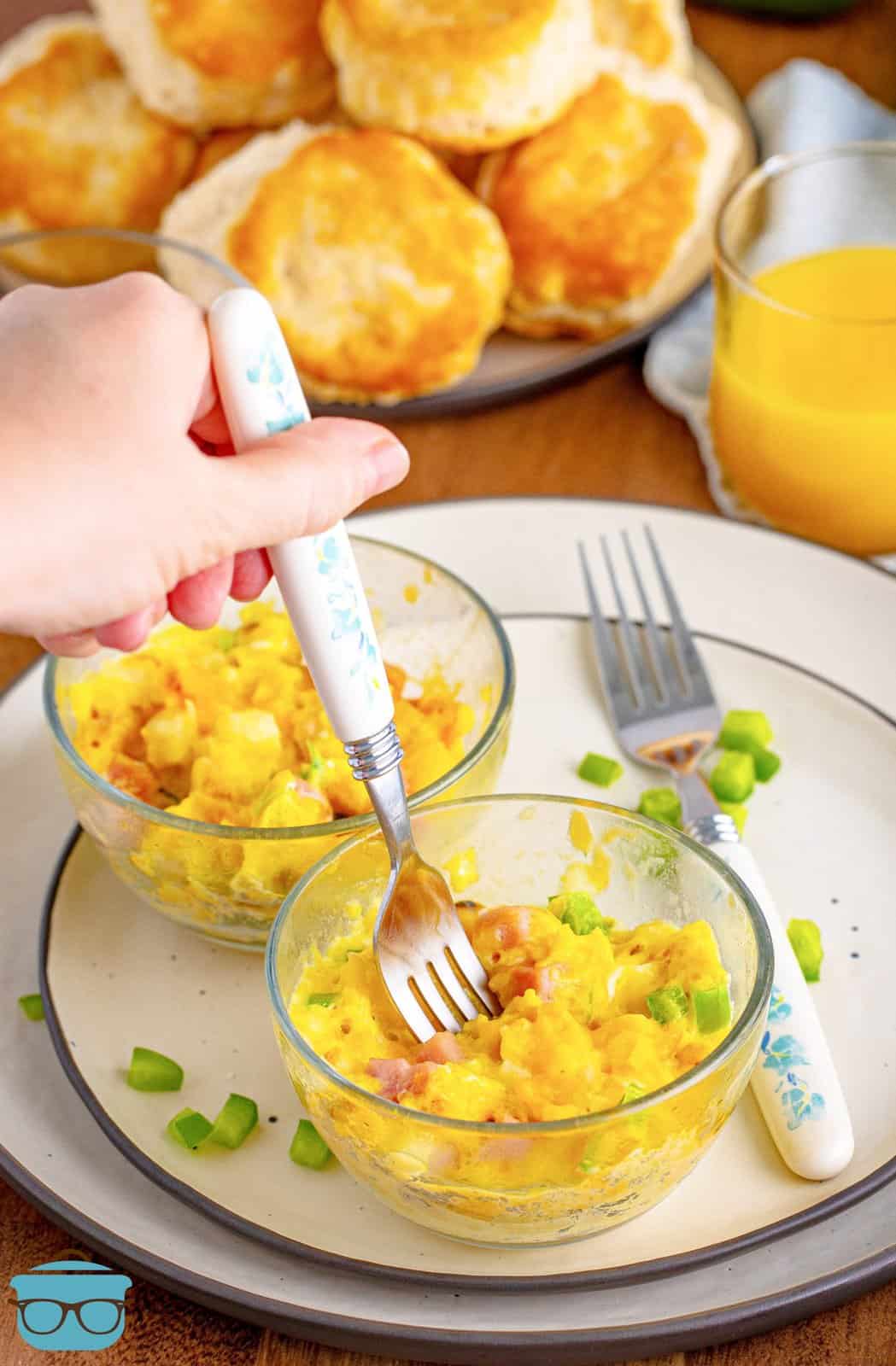A fork getting a bite from a Microwave Scrambled Eggs Cup on a plate.