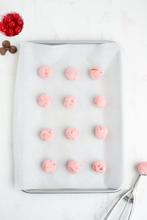 Cherry Blossom Cookie dough balls on a parchment lined baking sheet.