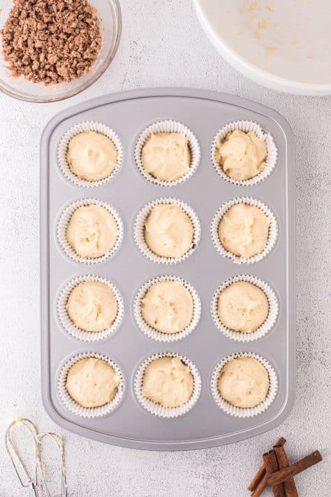 A lined muffin tin filled with muffin batter.