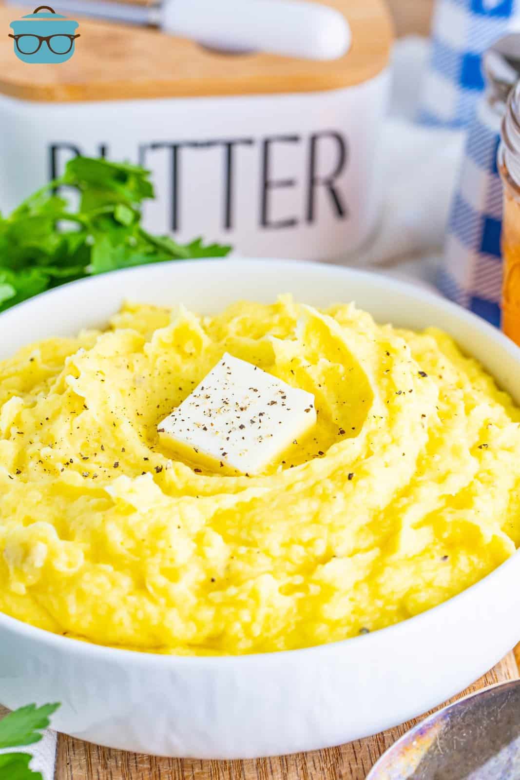 A large bowl of Stovetop mashed potatoes with a pad of butter on top.