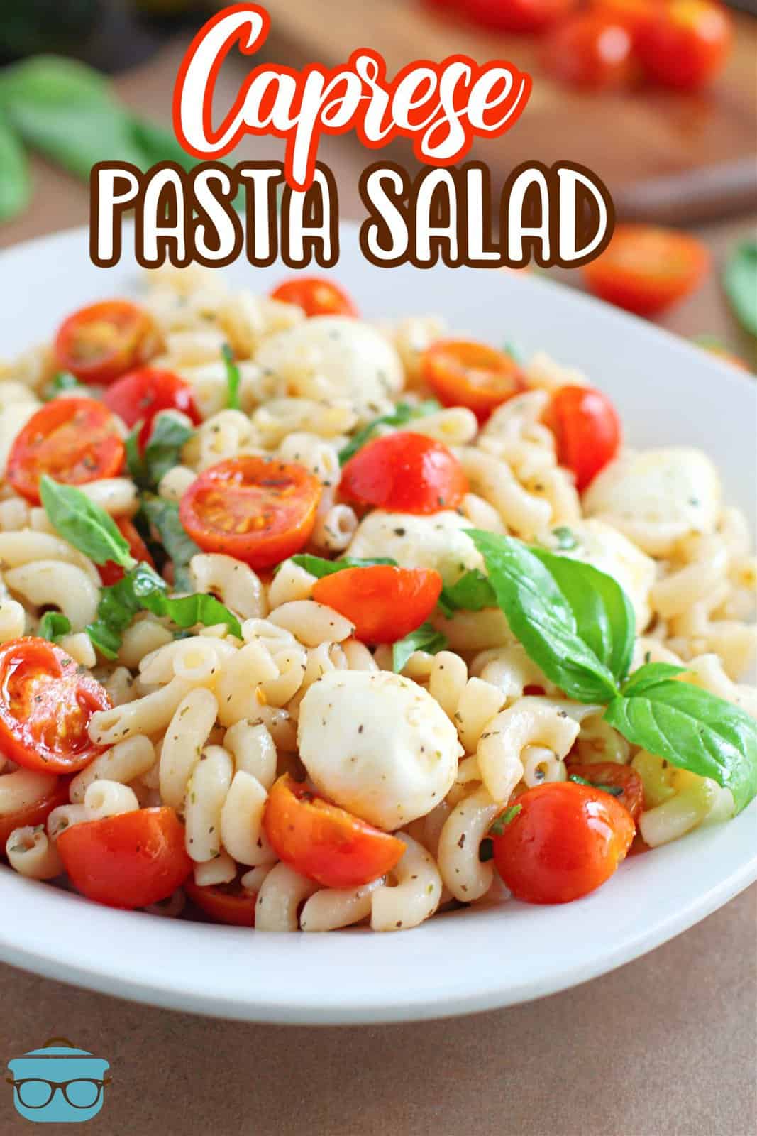 A white serving bowl with Caprese Pasta Salad in it.