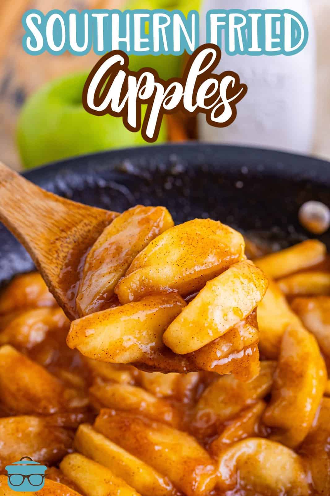 Fried Apples in a skillet with a wooden spoon scooping some out.