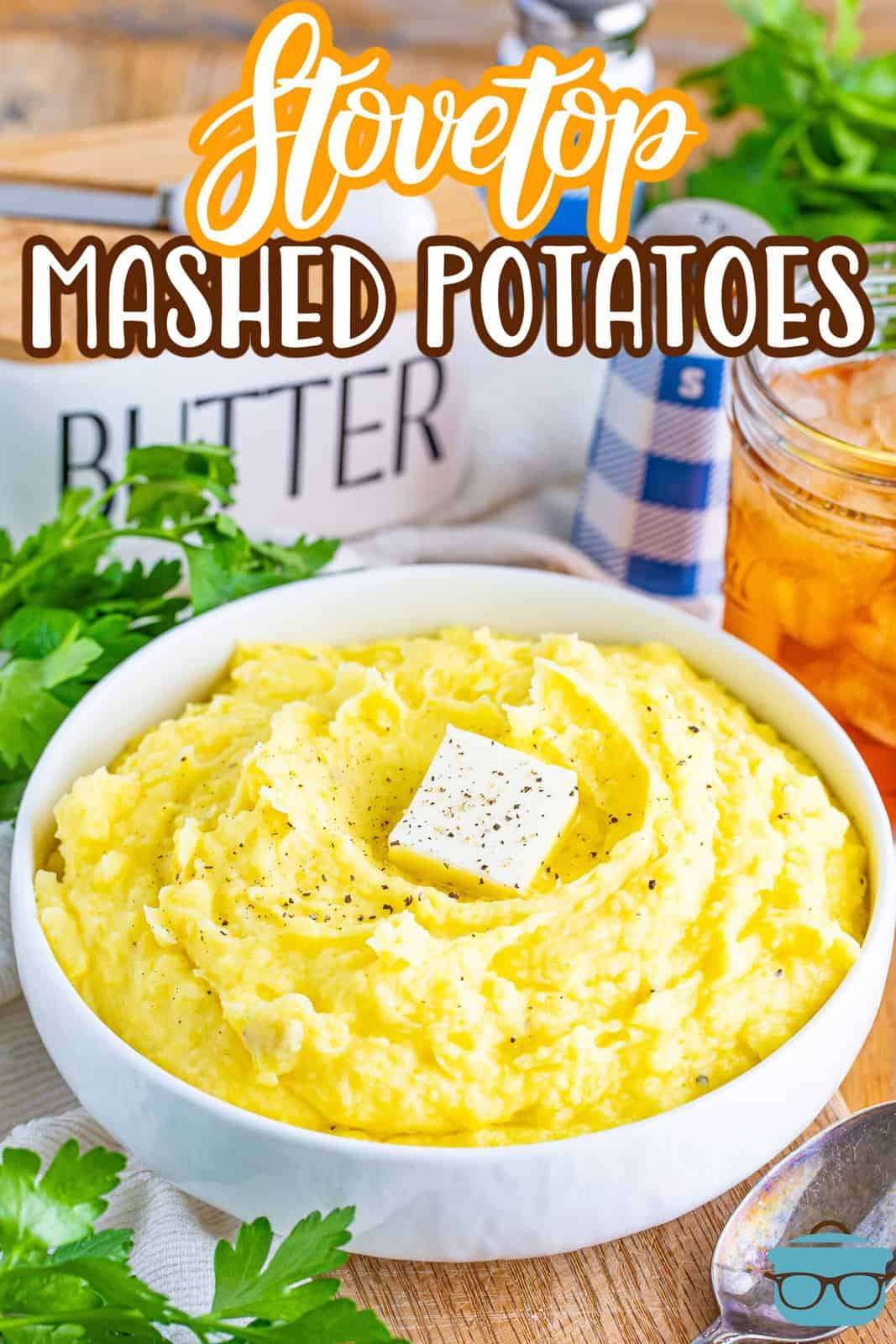 A big bowl of Stovetop Mashed Potatoes with butter and garnish on top.