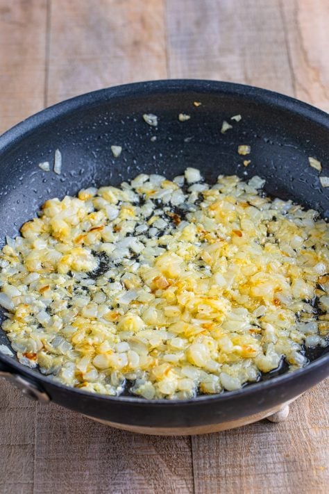 Butter and onions cooking in a skillet.
