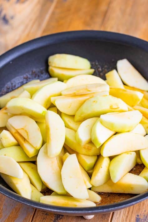 slices of apples added to skillet.