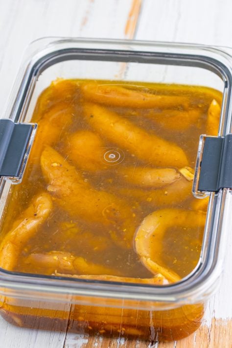 A closed container of marinating chicken.