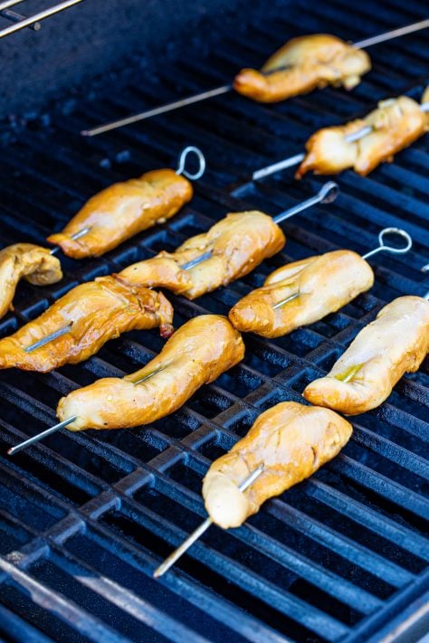 Marinated chicken on skewers on the grill.
