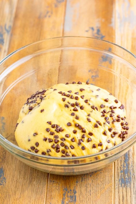 Mini chocolate chip hot cross bun dough in a glass mixing bowl.