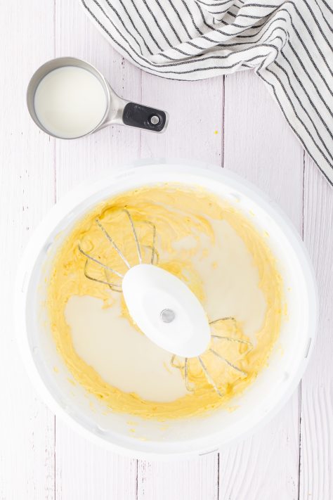 Warm milk being added gradually to a cake batter.