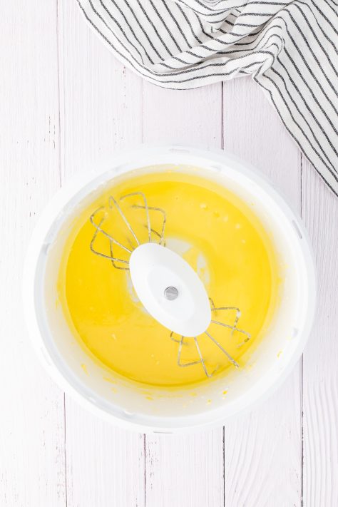 Melted butter being added to a lemon cake mix.