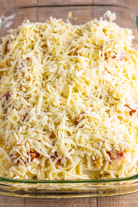 Shredded mozzarella cheese on top of a pierogi casserole.