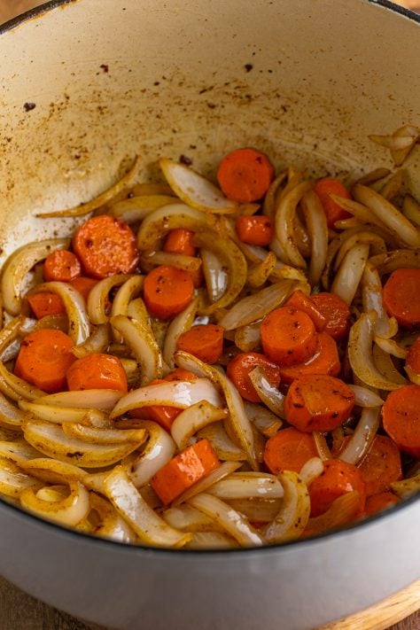Carrots and onions in a Dutch oven.
