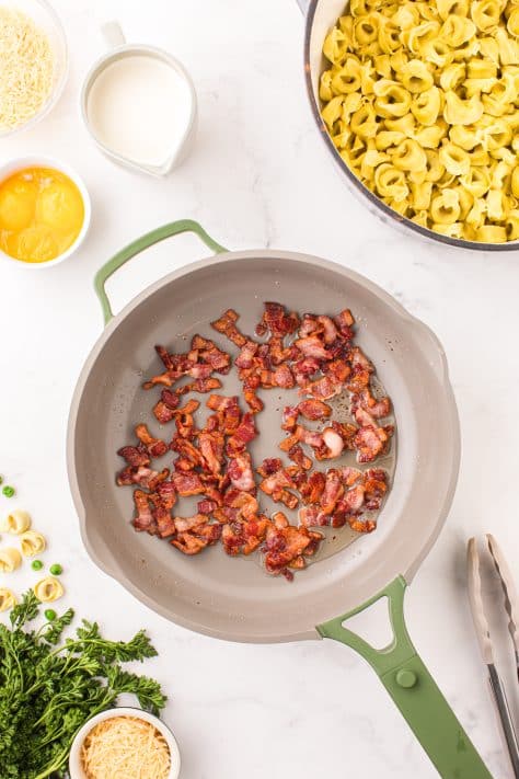 cooked bacon pieces in a skillet.