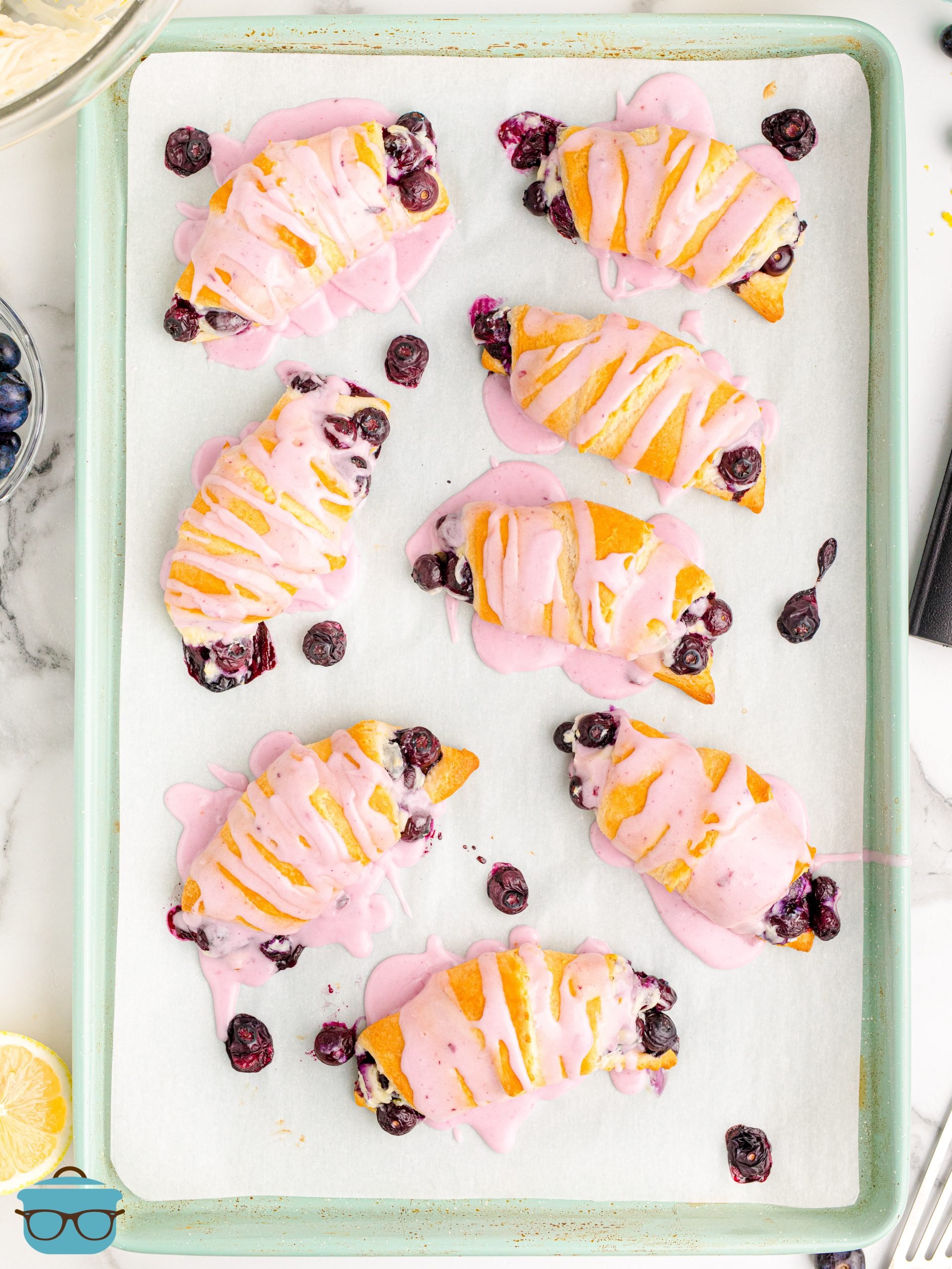 Looking down on a baking sheet of Blueberry Cheesecake Crescent Rolls.