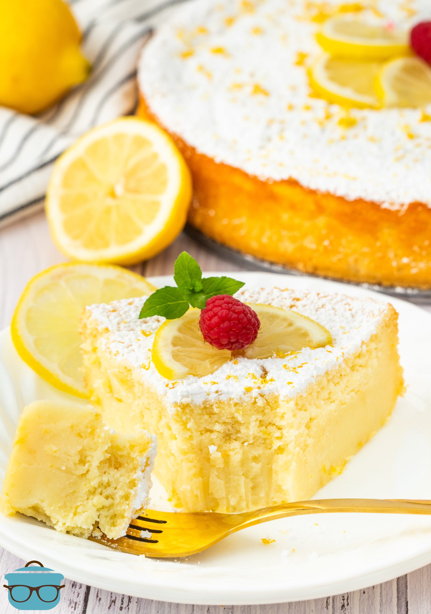 A slice of Lemon Magic Cake with a fork holding a bite.