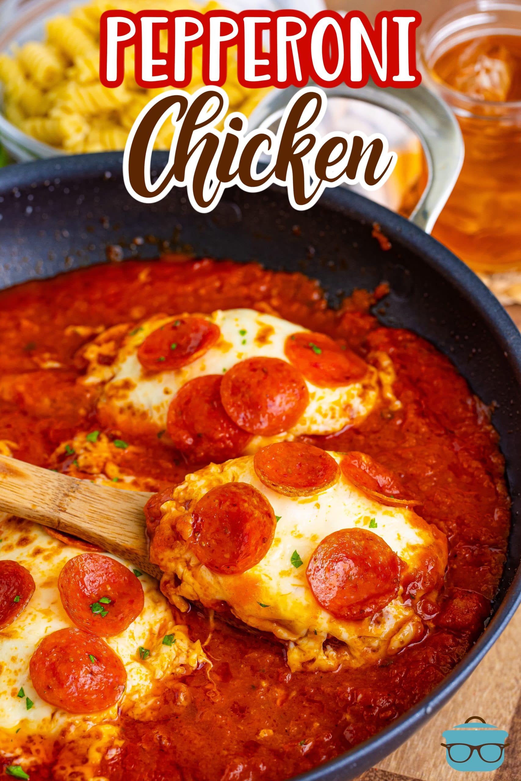 A skillet of Pepperoni Chicken with a wooden spoon.