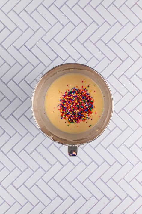 sprinkles added to cupcake batter in mixing bowl.