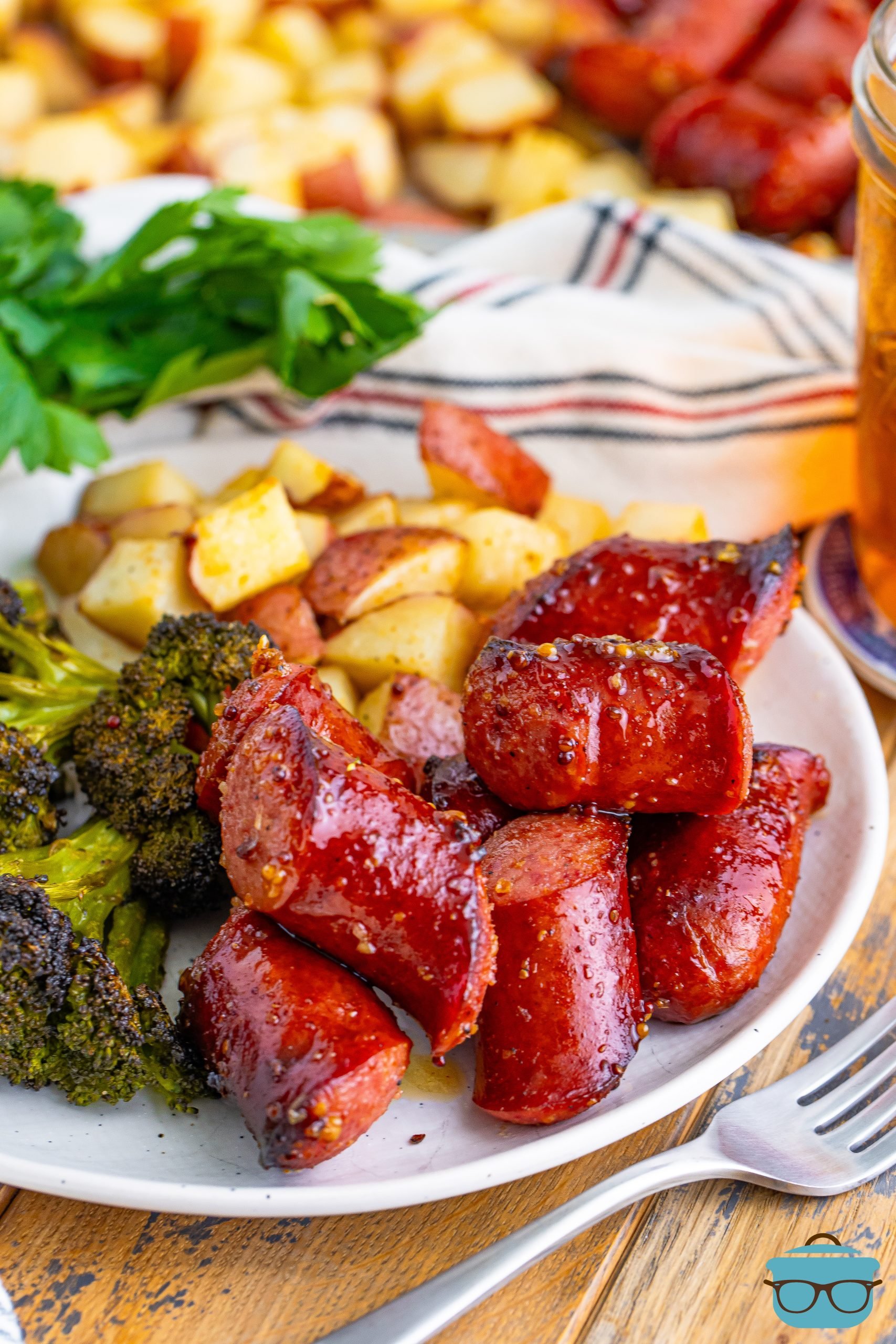 A plate with Kielbasa and sides on it.