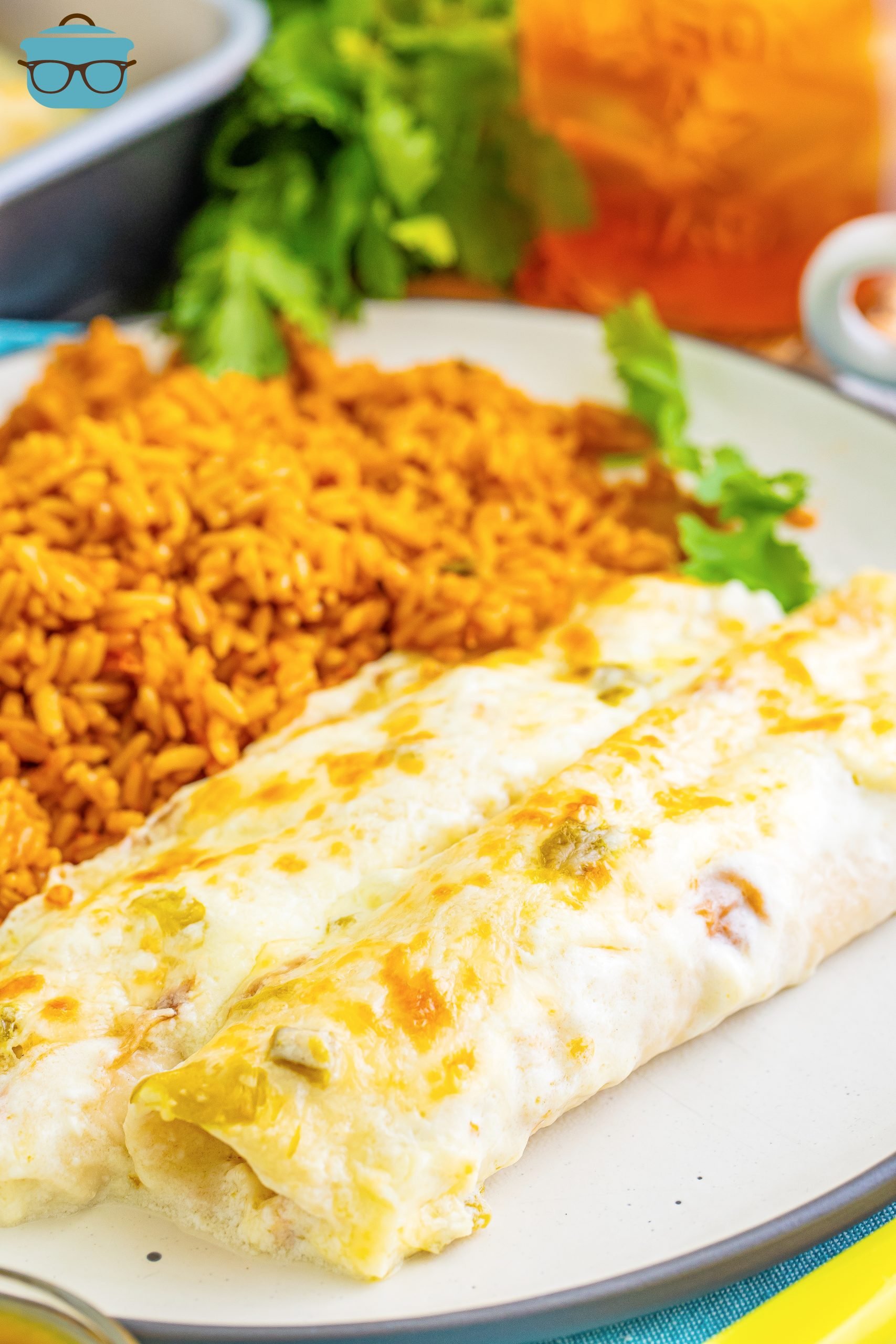 A plate with White Chicken Enchiladas and rice. 