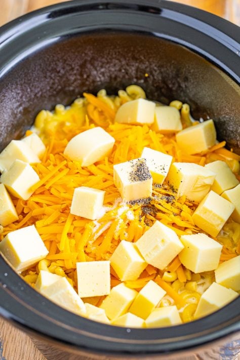 cubed and shredded cheeses added to slow cooker.