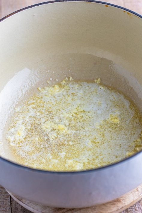 Melted butter and garlic in a Dutch oven.