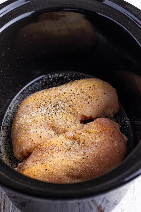Seasoned chicken breast in a Crock Pot.