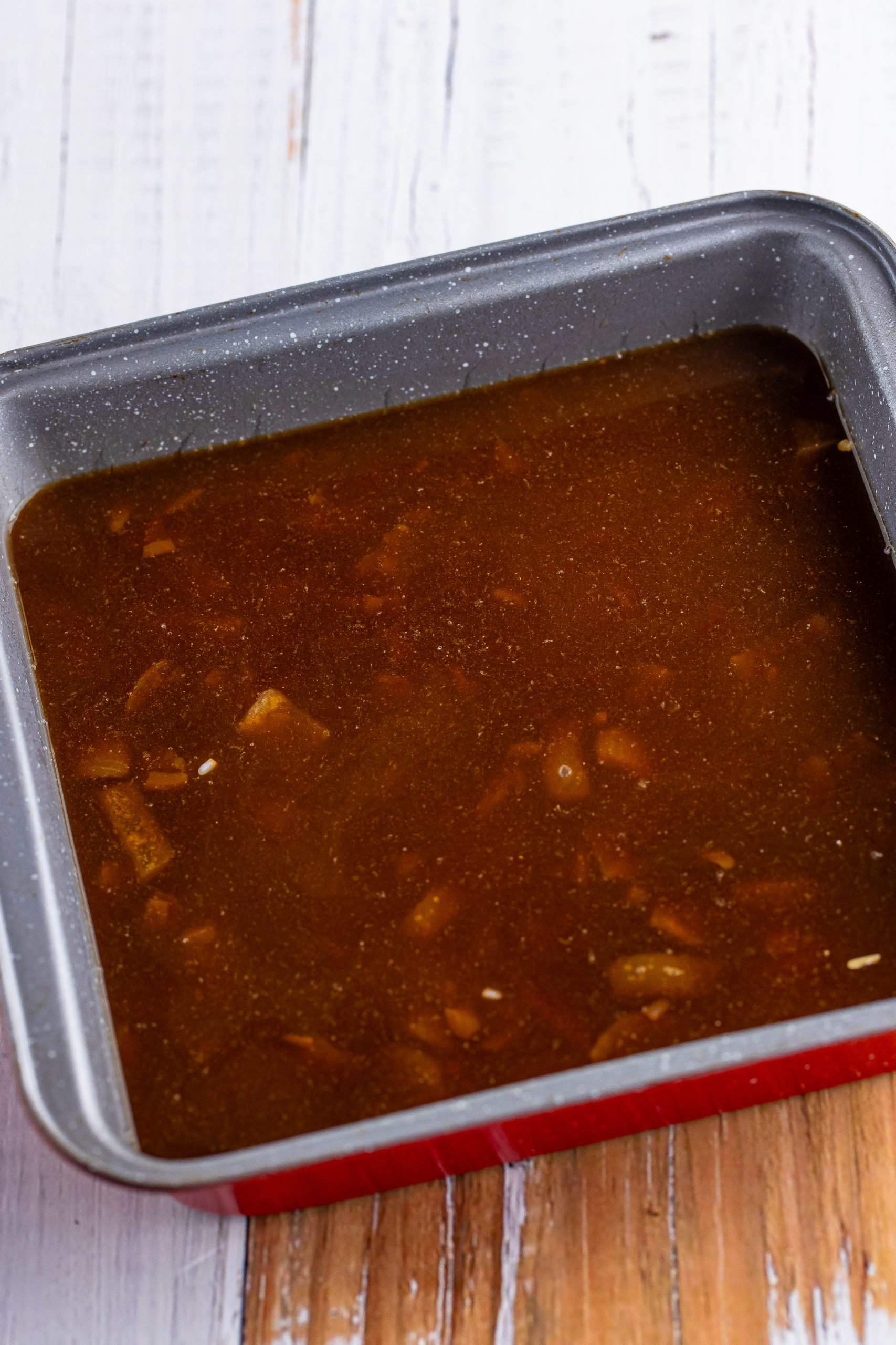 A baking dish with rice, beef broth, and onion soup.