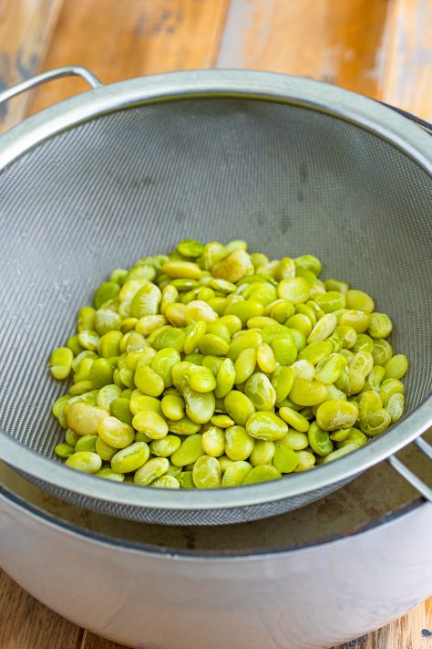 Boiled lima beans in a strainer.