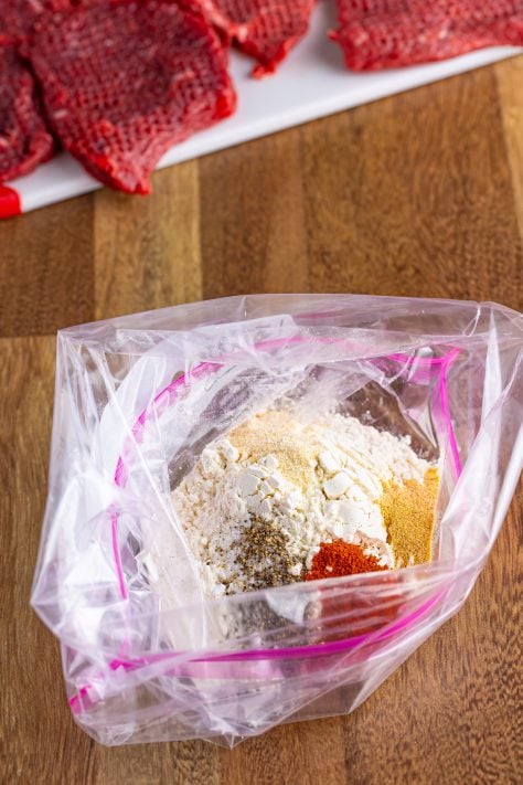 seasonings and flour added to a Ziploc bag.
