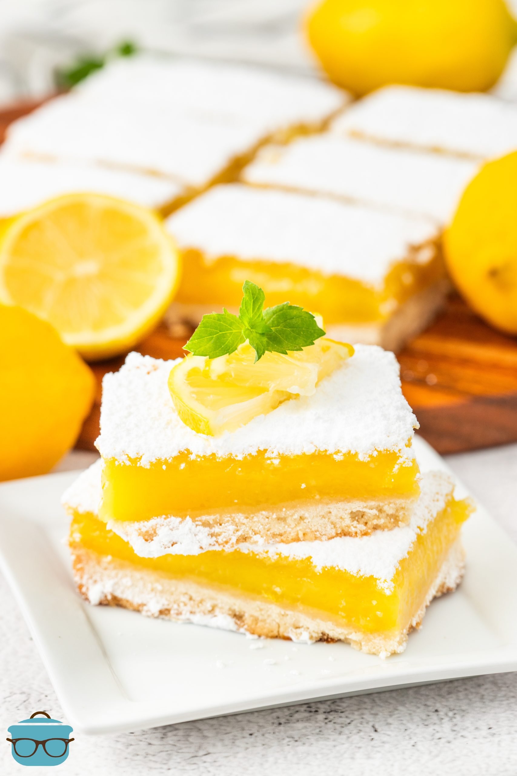 Two stacked Lemon Bars on a plate. 
