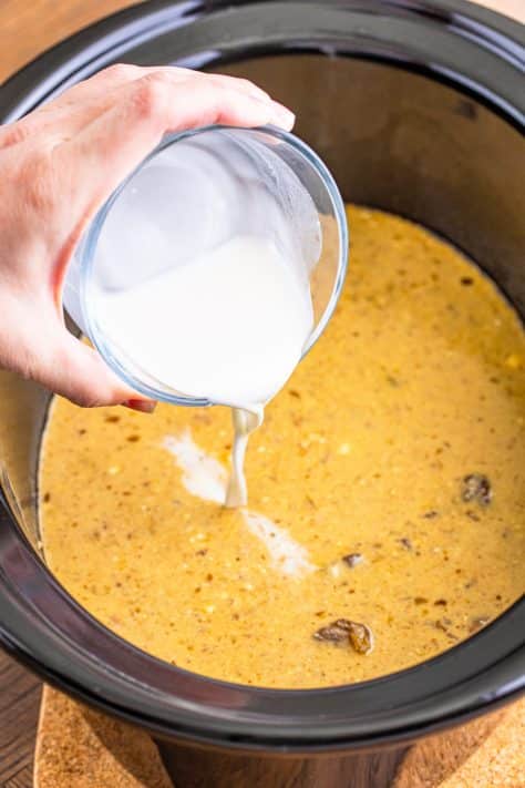 A cornstarch slurry being added to a Crock Pot.