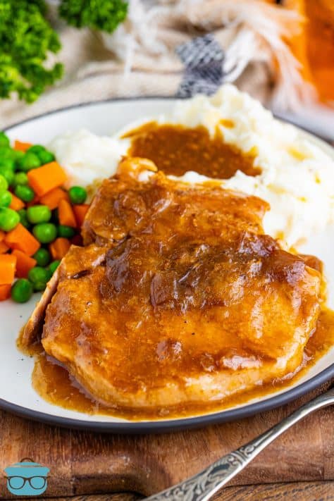 A plated dinner with a Crock Pot Pork Chop with sides.