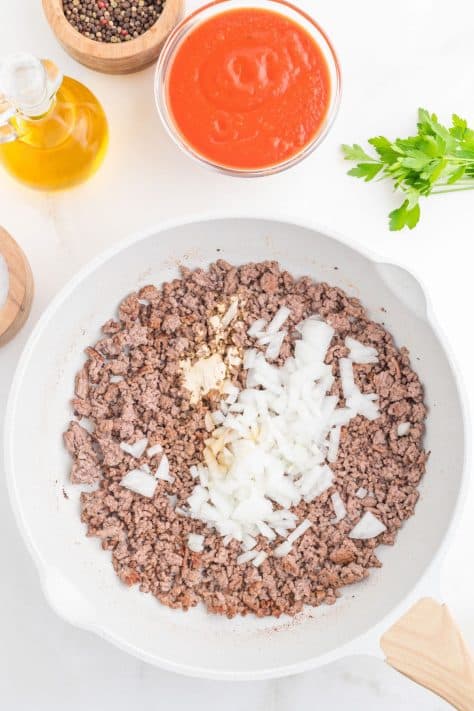 Ground beef and onion in a skillet.