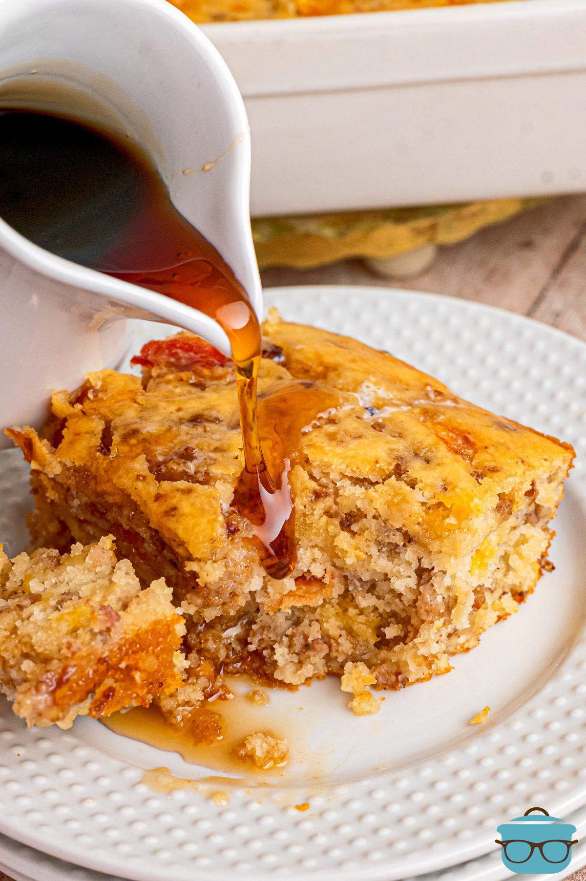 A plate with a serving of McGriddle Casserole and syrup being poured over it. 