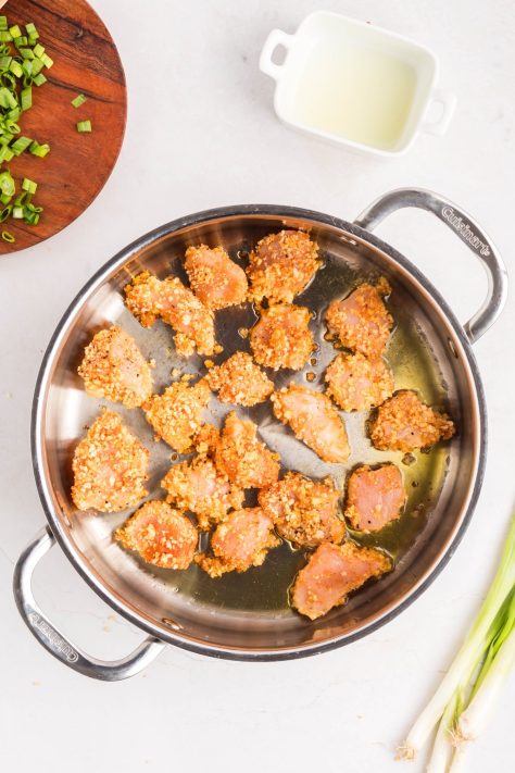 Chicken cooking in a skillet.