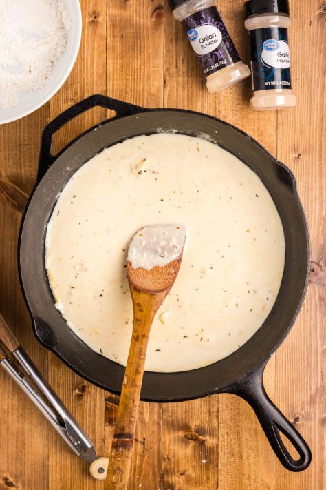 Cream sauce with a wooden spoon.