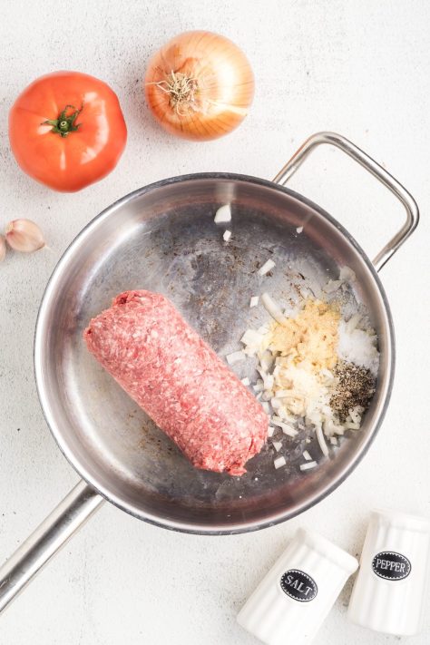 A skillet with ground beef and onions.