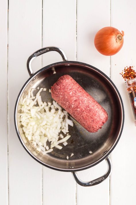 Ground beef and onions in a skillet.