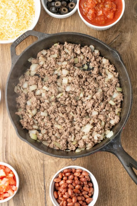 Ground beef and onions in a skillet.