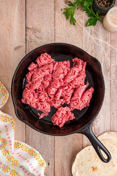 Beef cooking in a skillet.