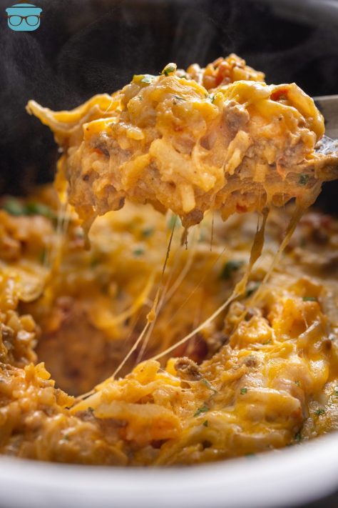 A scoop of Crock Pot Taco Casserole above the Slow Cooker.