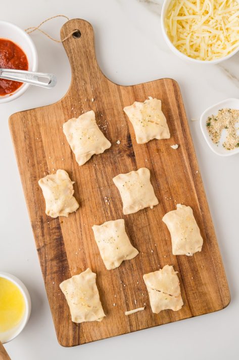Unbaked crescent rolls with sauce and cheese stuffed inside.