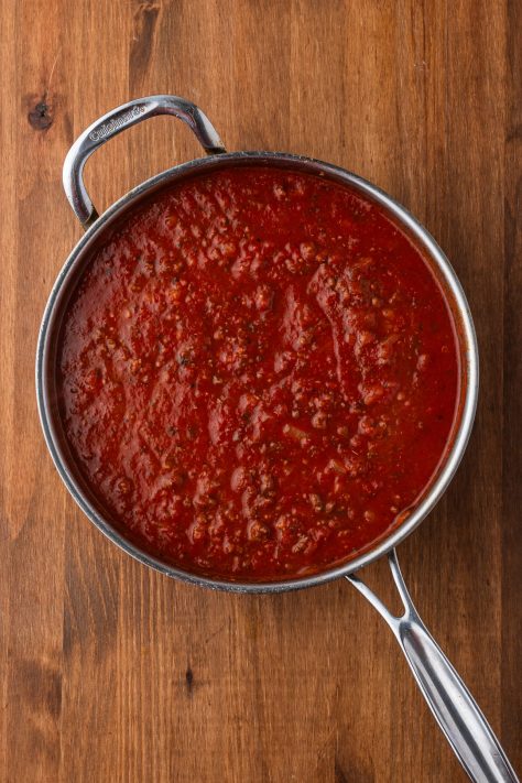 Beef, onion, sauce and seasonings cooking in a skillet.