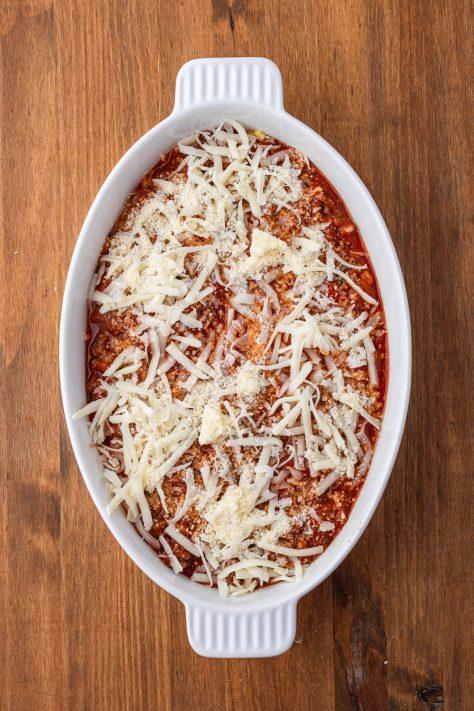 Layers of cheese, sauce and beef in a baking dish.