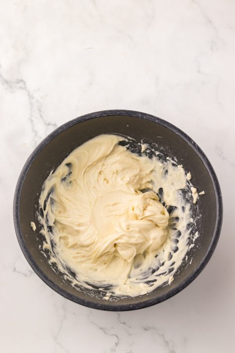 A bowl of cream cheese, powdered sugar, and vanilla mixed together.