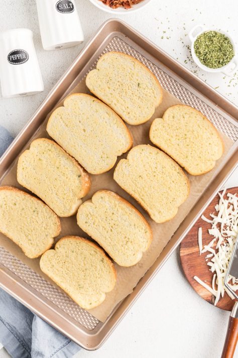 Pieces of Texas toast on a baking sheet.