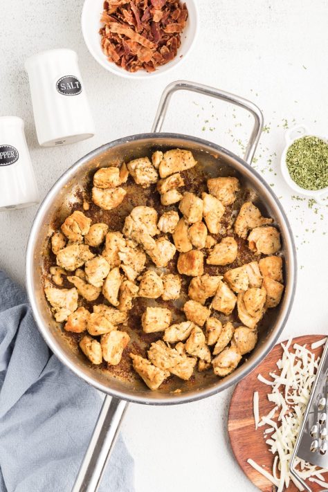 Cooked and seasoned pieces of chicken in a skillet.